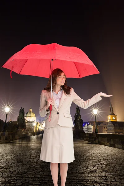 Atractiva empresaria sosteniendo paraguas rojo — Foto de Stock