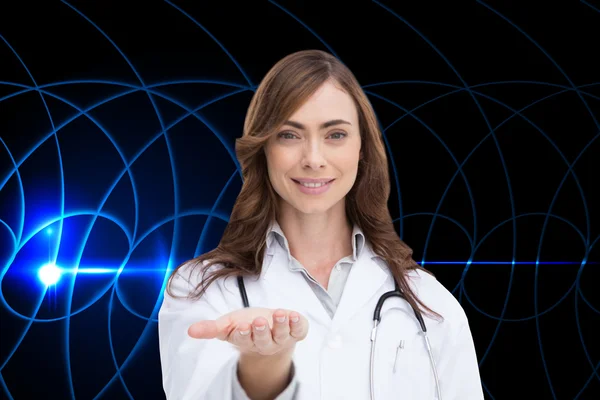 Samengestelde afbeelding van lachende arts presenteren van haar hand — Stockfoto