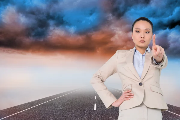 Composite image of unsmiling asian businesswoman pointing — Stock Photo, Image