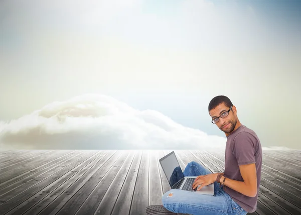 Homem usando óculos sentado no chão usando laptop — Fotografia de Stock