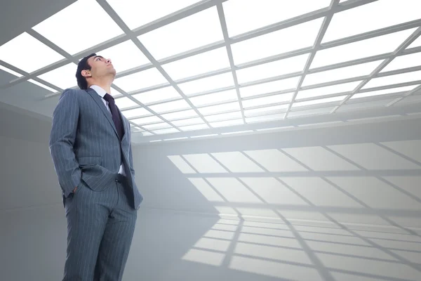 Composite image of unsmiling businessman standing — Stock Photo, Image