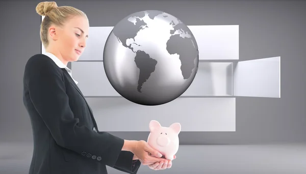 Composite image of businesswoman holding piggy bank — Stock Photo, Image