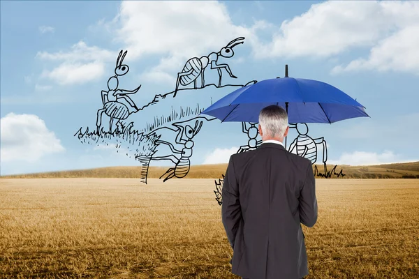 Composite image of businessman holding umbrella — Stock Photo, Image