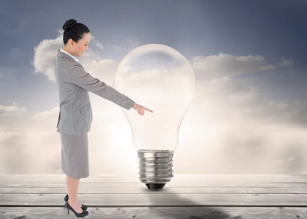 Composite image of smiling asian businesswoman pointing — Stock Photo, Image