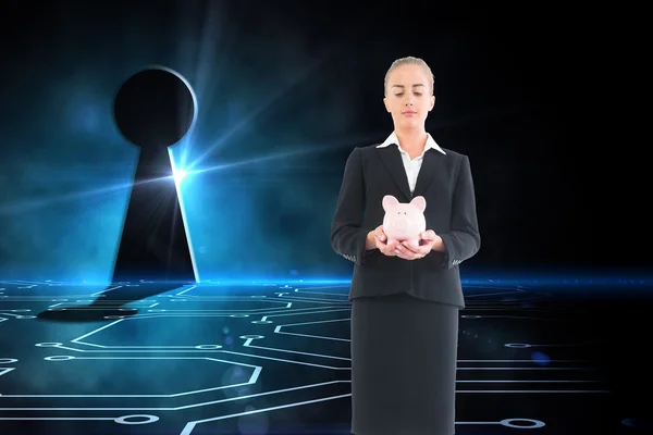 Composite image of businesswoman holding pink piggy bank — Stock Photo, Image