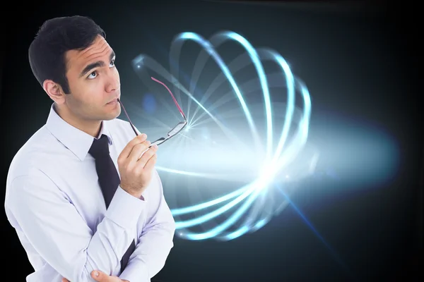 Imagen compuesta de hombre de negocios pensando sosteniendo gafas — Foto de Stock