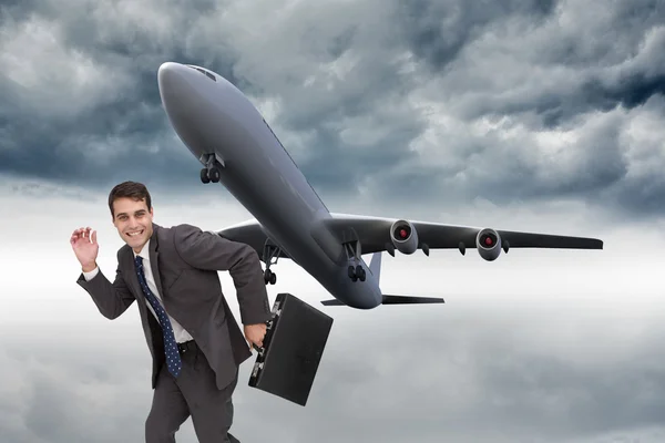 Composite image of happy businessman in a hury — Stock Photo, Image