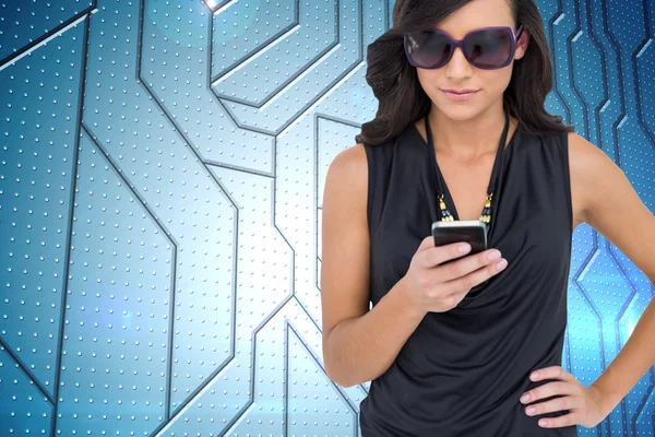 Composite image of happy brunette using smartphone — Stock Photo, Image