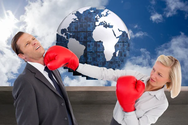 Composite image of businesswoman hitting colleague with her boxi — Stock Photo, Image