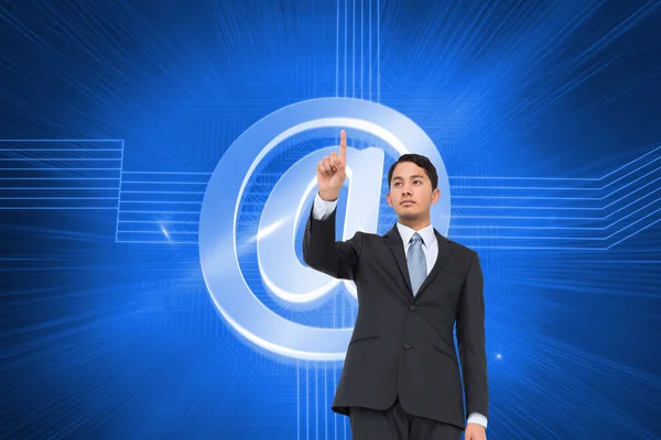 Composite image of serious asian businessman pointing — Stock Photo, Image