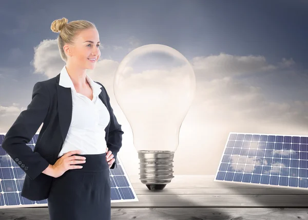 Composite image of businesswoman standing with hands on hips — Stock Photo, Image