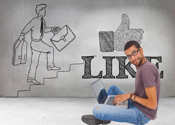 Man wearing glasses sitting on floor using laptop — Stock Photo, Image