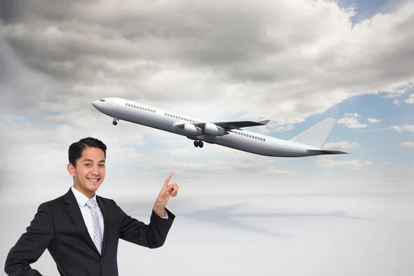 Composite image of smiling asian businessman pointing — Stock Photo, Image