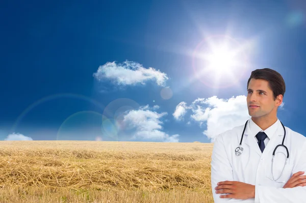 Confident doctor with arms crossed looking up — Stock Photo, Image