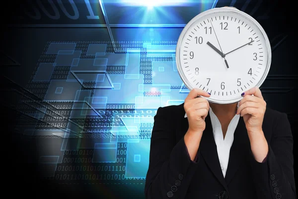 Composite image of businesswoman in suit holding a clock — Stock Photo, Image