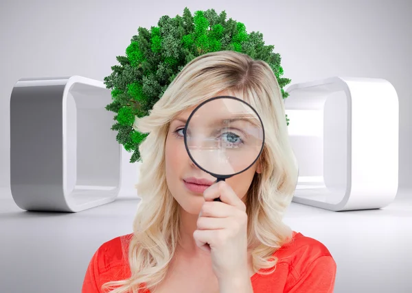 Woman looking through a magnifying glass — Stock Photo, Image