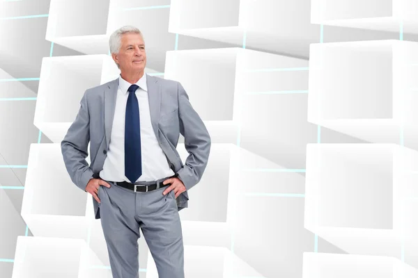 Composite image of man in a suit with his hands on his hips — Stock Photo, Image