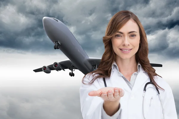 Composite image of portrait of female nurse holding out open palm — Stock Photo, Image