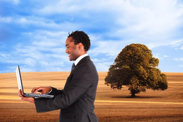 Composite image of businessman working on laptop — Stock Photo, Image