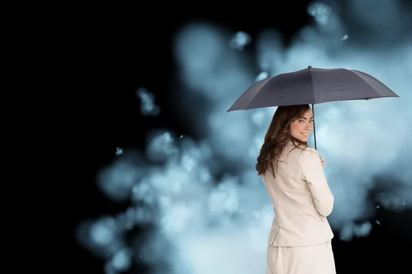 Samengestelde afbeelding van Achteraanzicht van stijlvolle zakenvrouw houden paraplu — Stockfoto