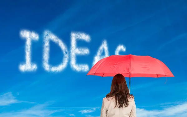 Composite image of businesswoman standing back to camera holding — Stock Photo, Image