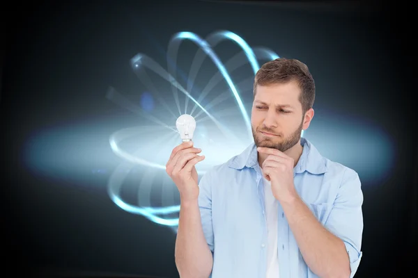 Sceptical model holding a bulb — Stock Photo, Image