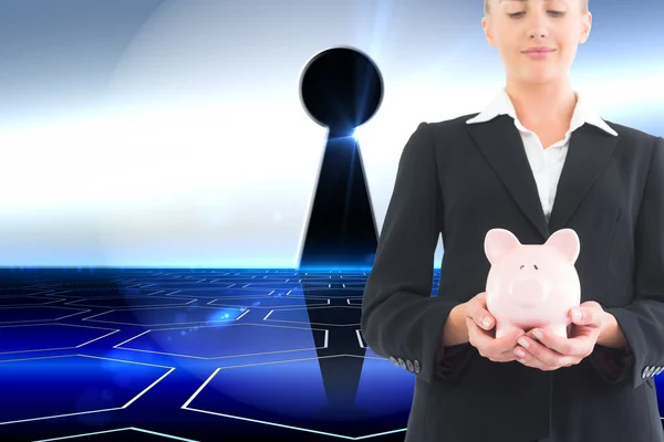 Composite image of businesswoman holding piggy bank — Stock Photo, Image