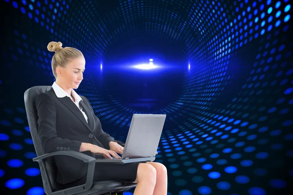 Dizüstü bilgisayar ile döner sandalye üzerinde oturan iş kadını — Stok fotoğraf