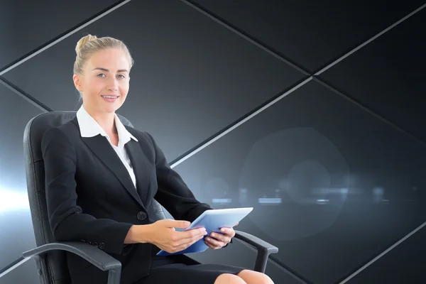 Composite image of businesswoman sitting on swivel chair with tablet — Stock Photo, Image