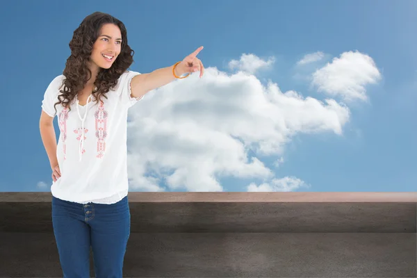 Composite image of cheerful attractive brunette wearing casual clothes pointing — Stock Photo, Image