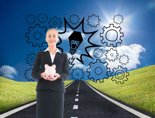 Composite image of businesswoman holding pink piggy bank — Stock Photo, Image