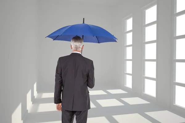 Composite image of businessman holding umbrella — Stock Photo, Image