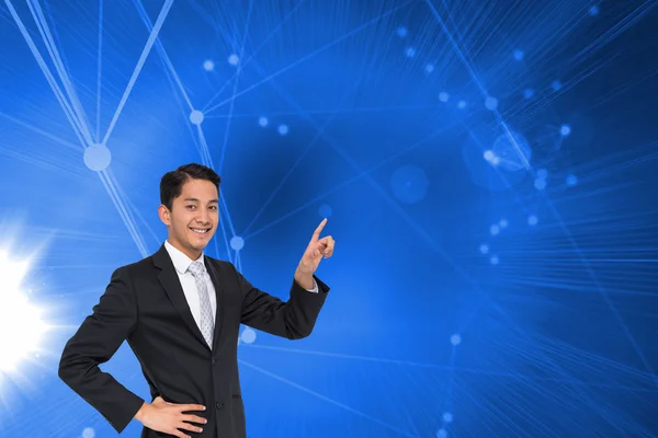 Composite image of smiling asian businessman pointing — Stock Photo, Image