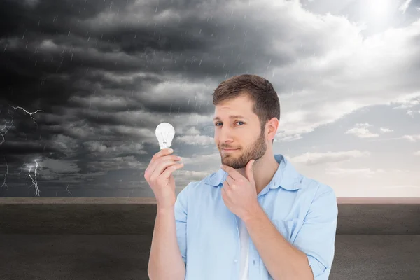 Handsome model holding a bulb — Stockfoto