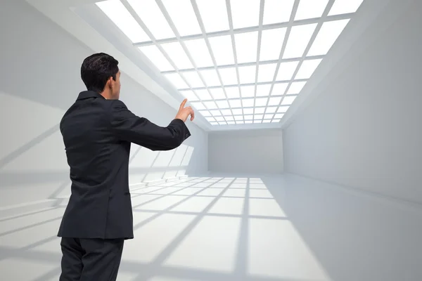 Composite image of thoughtful asian businessman pointing — Stock Photo, Image