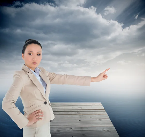 Immagine composita di donna d'affari asiatica non sorridente che indica — Foto Stock