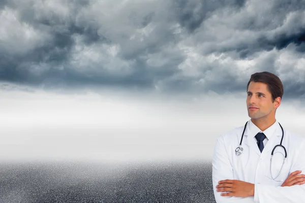 Composite image of confident doctor with arms crossed looking up — Stock Photo, Image
