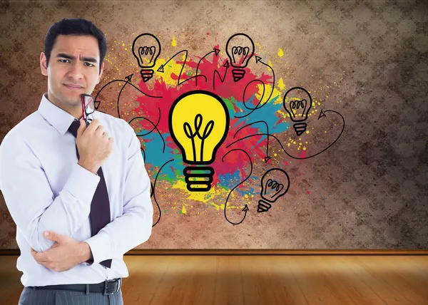 Composite image of thinking businessman holding glasses — Stock Photo, Image