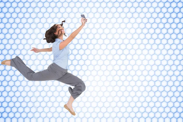 Composite image of happy classy businesswoman jumping — Stock Photo, Image