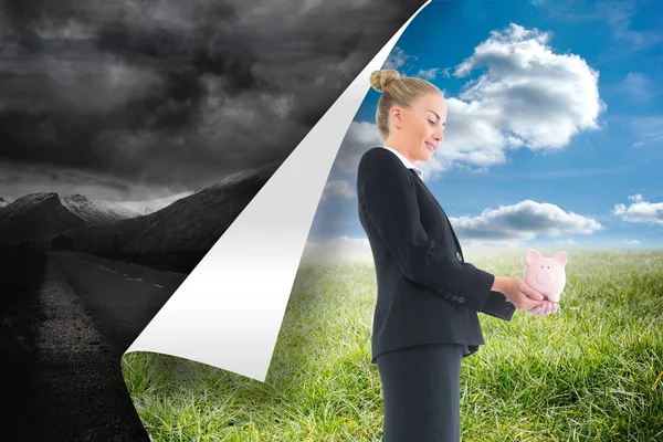 Composite image of businesswoman holding pink piggy bank — Stock Photo, Image