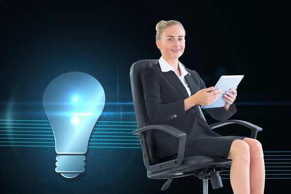 Composite image of businesswoman sitting on swivel chair with tablet — Stock Photo, Image