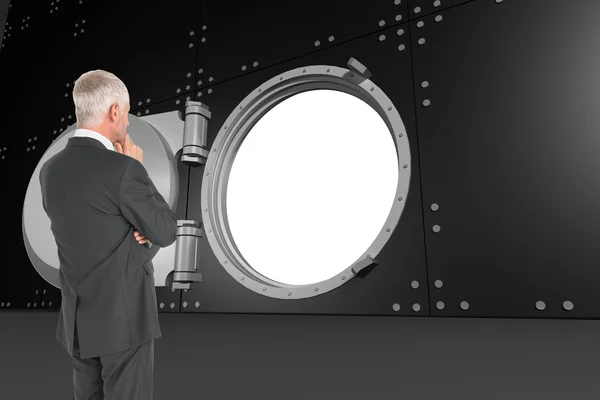 Composite image of thoughtful businessman standing back to camer — Stock Photo, Image