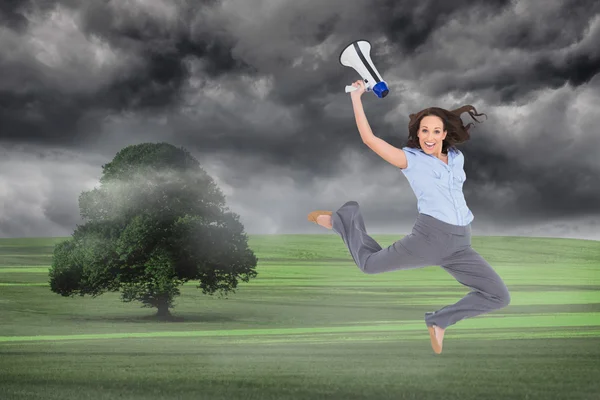 Classy businesswoman jumping while holding megaphone — Stock Photo, Image