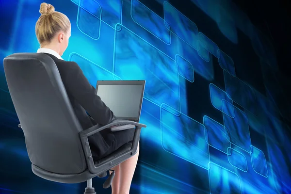 Mulher de negócios loira sentada na cadeira giratória com laptop — Fotografia de Stock