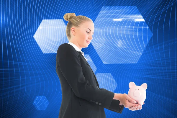 Composite image of businesswoman holding piggy bank — Stock Photo, Image