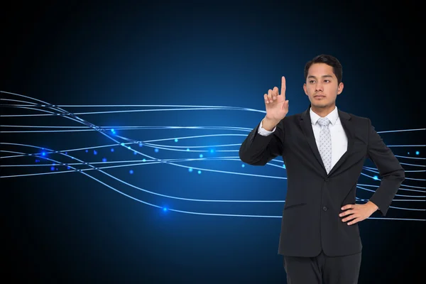 Composite image of unsmiling asian businessman pointing — Stock Photo, Image