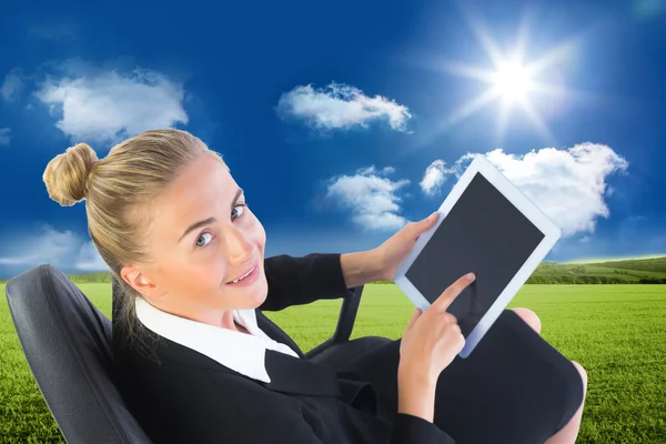 Blonde businesswoman sitting on swivel chair with tablet — Stock Photo, Image