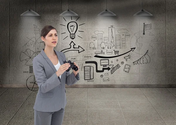 Curious young businesswoman with binoculars — Stock Photo, Image