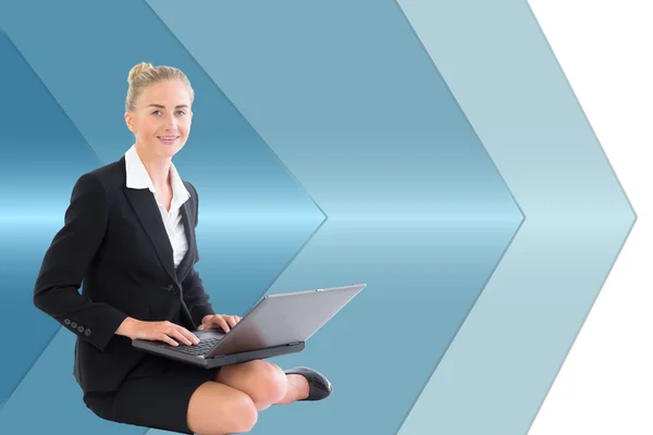 Composite image of businesswoman using laptop — Stock Photo, Image