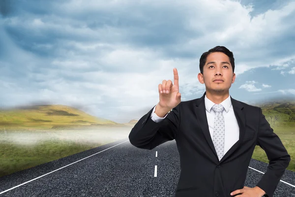 Composite image of unsmiling asian businessman pointing — Stock Photo, Image